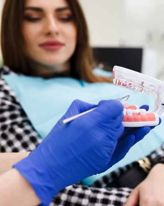 Dentist in Glendale demonstrating root canal retreatment with a model